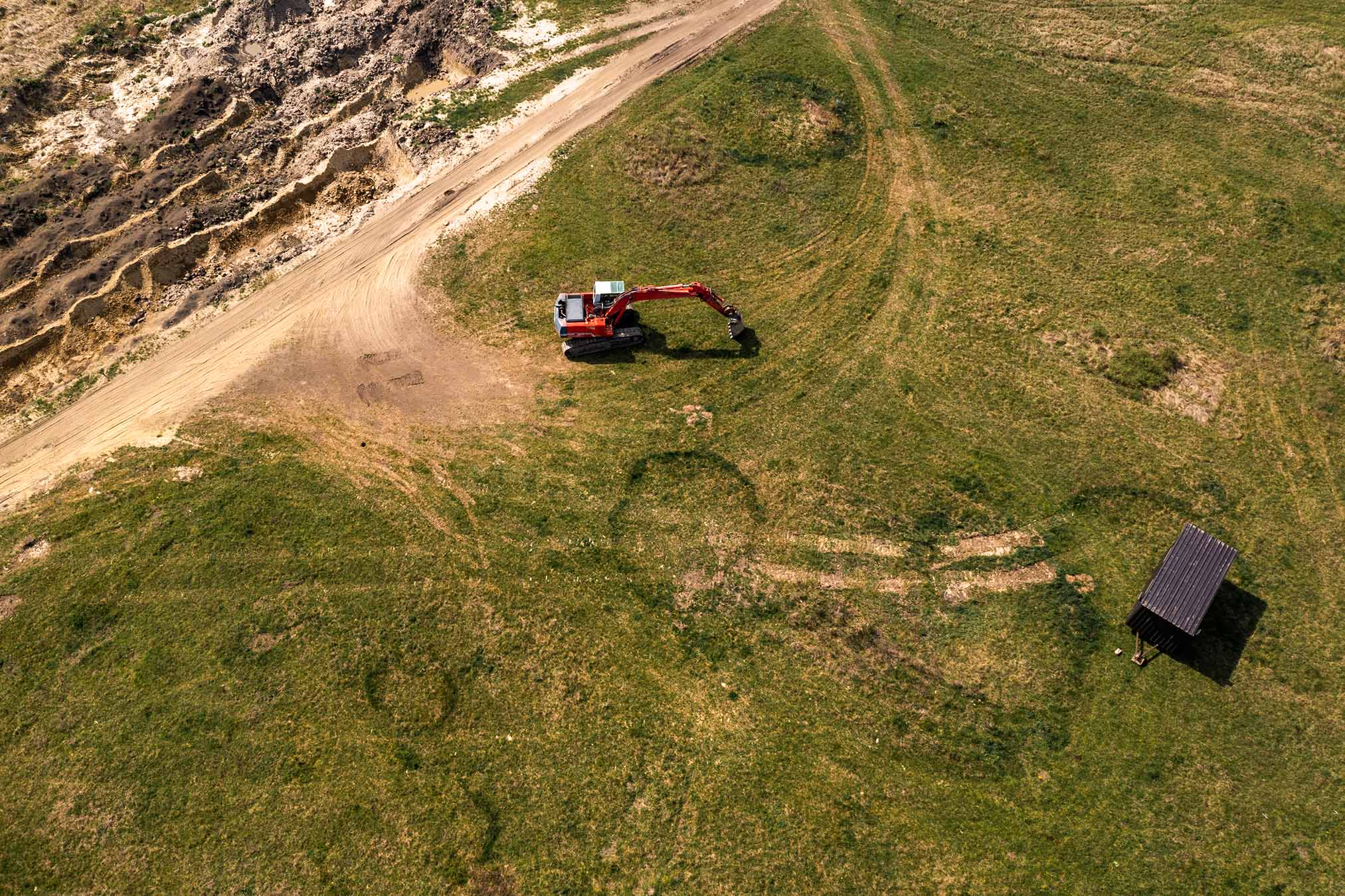 Excavator machinery on archeological site, aerial shot from drone pov, high angle view